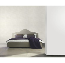 Chambre avec papier peint à motifs, lit et coussins décoratifs