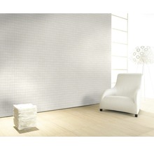 Pièce claire avec papier peint à motifs, fauteuil et lampe