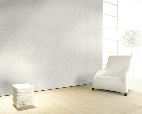 Pièce claire avec papier peint à motifs, fauteuil et lampe