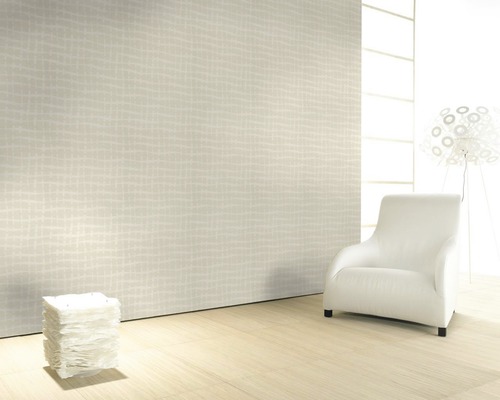 Heller Raum mit gemusterter Tapete, Sessel und Lampe.