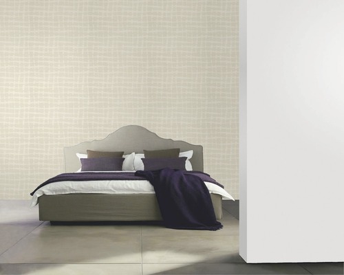 Schlafzimmer mit gemusterter Tapete, Bett, Kissen und Tagesdecke