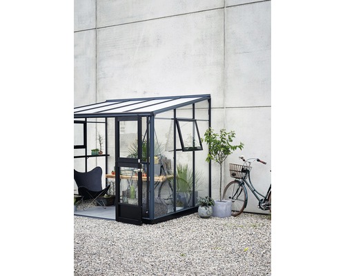 Gewächshaus mit offenstehender Tür, Pflanzen und Fahrrad im Garten
