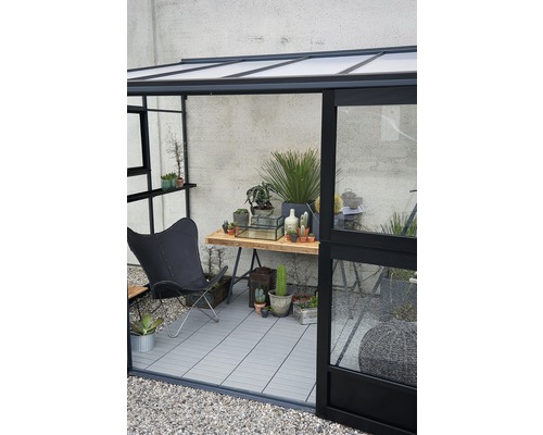 Innenansicht eines Gewächshauses mit Stuhl, Tisch und Pflanzen