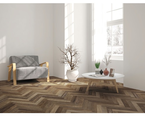 Wohnzimmer mit Sessel, Tisch und Parkettboden