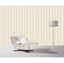 Papier peint à rayures, fauteuil et lampadaire dans une pièce.