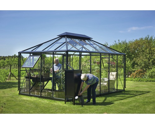 Gewächshaus mit Pflanzen und zwei Personen im Garten