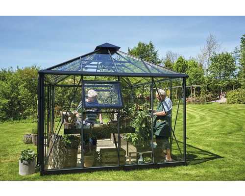 Gewächshaus mit Pflanzen und zwei Personen im Garten