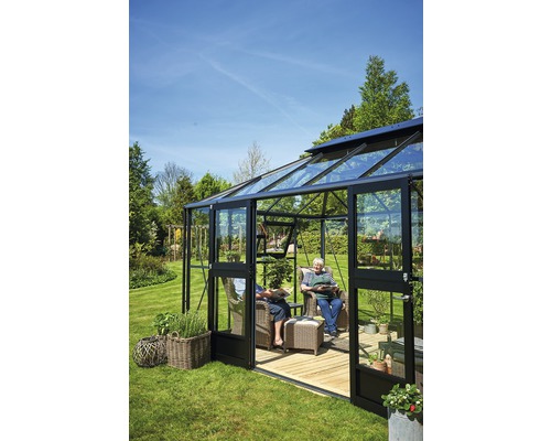 Gewächshaus mit Glaswänden, Gartenstühlen und Personen im Garten