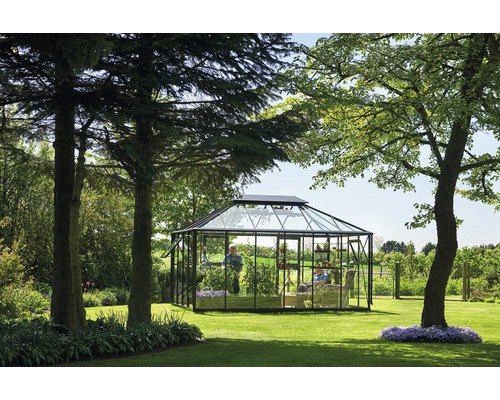 Gewächshaus aus Glas mit Personen im Garten