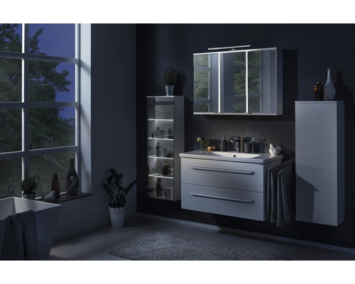 Salle de bain moderne avec lavabo, armoire de toilette, armoire haute et baignoire.