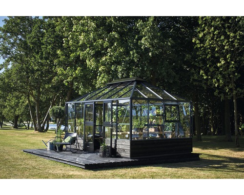 Gewächshaus auf Holzterrasse im Garten mit Bäumen