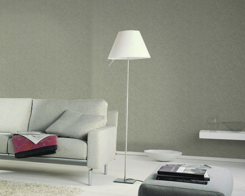 Salon avec canapé, lampadaire et papier peint à motifs pour une ambiance élégante