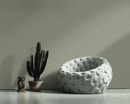 Vue intérieure avec fauteuil, cactus et figurine décorative devant un mur à motifs