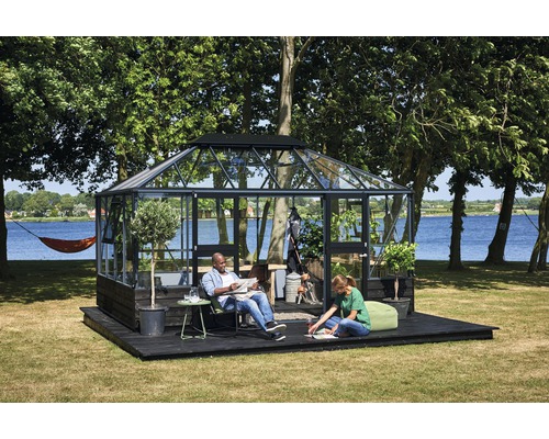 Gewächshaus mit Personen auf einer Holzterrasse im Garten