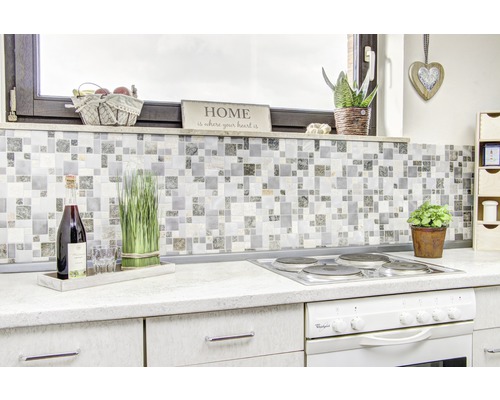 Scène de cuisine avec des carreaux de mosaïque, une cuisinière et des éléments décoratifs pour une atmosphère chaleureuse.