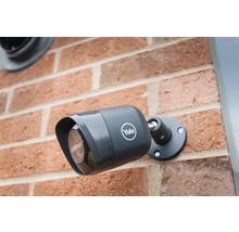 Caméra de surveillance Logo Yale montée sur un mur en briques