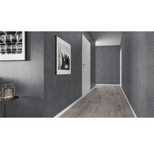 Couloir avec papier peint gris, sol en bois clair et portes blanches