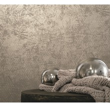 Papier peint à motif structuré et deux boules décoratives sur un tabouret