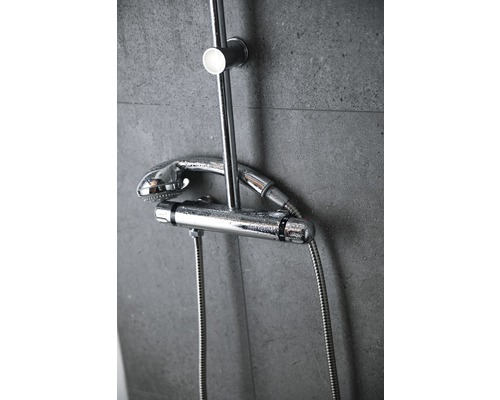 Mitigeur thermostatique de douche avec douchette de tête et douchette à main sur un mur gris