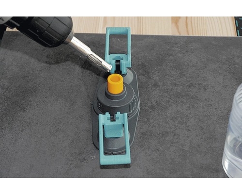 Perceuse en train de percer à travers un gabarit de perçage