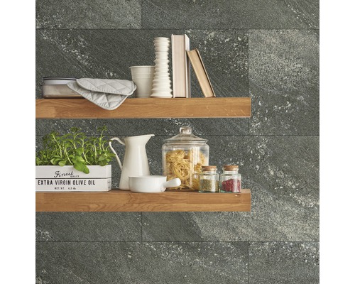 Scène de cuisine décorative avec étagères, vaisselle, ingrédients et carreaux muraux gris.