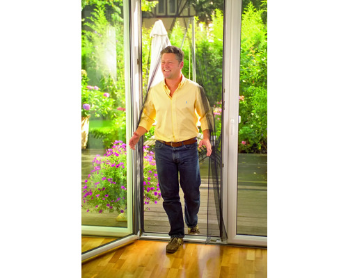 Un homme passe une porte avec une moustiquaire.