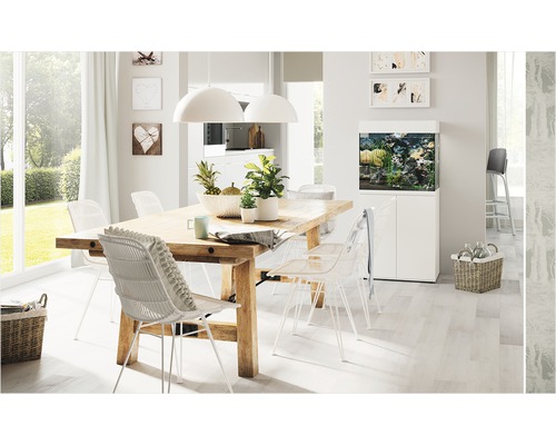 Salle à manger lumineuse avec table en bois, chaises et aquarium.