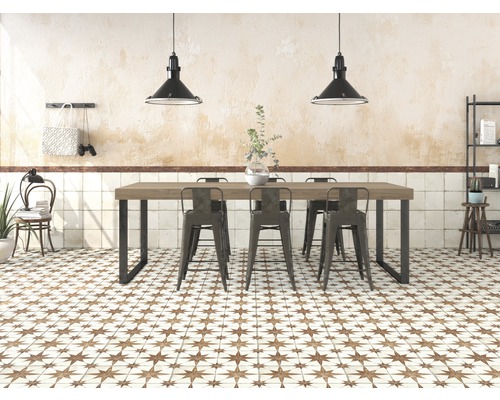 Heller Raum mit Esstisch, Stühlen, Fliesenboden mit Sternmuster und Pendelleuchten