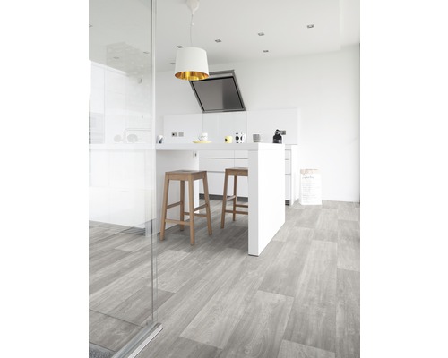 Cuisine claire avec sol en vinyle gris, îlot de cuisine et tabourets de bar.