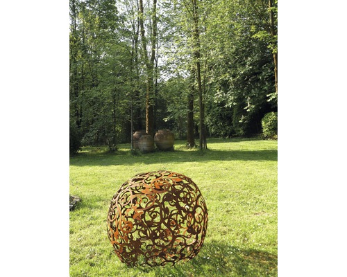 Scène extérieure avec une boule de jardin décorative en métal sur une pelouse