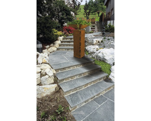 Gartenlandschaft mit Steintreppe und Pflanzgefäß aus Metall