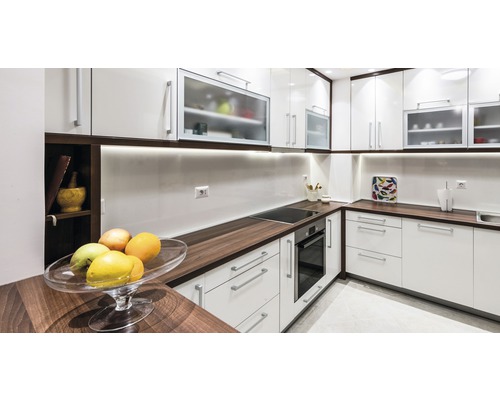 Cuisine lumineuse avec armoires blanches, plans de travail foncés et appareils intégrés pour un design moderne