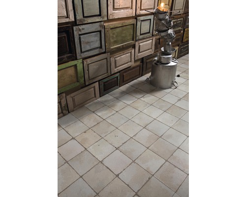 Mur fait de vieux cadres de porte avec lampadaire insolite et carreaux de sol