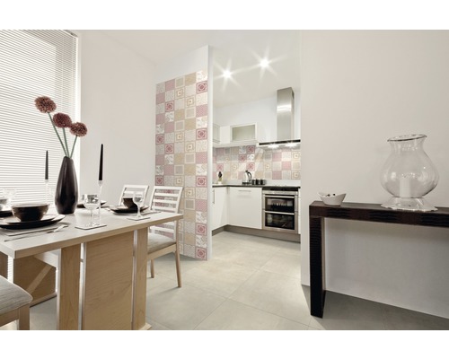 Esszimmer mit Esstisch, Stühlen und Wandfliesen im Patchwork-Stil, angrenzend an eine helle Küche