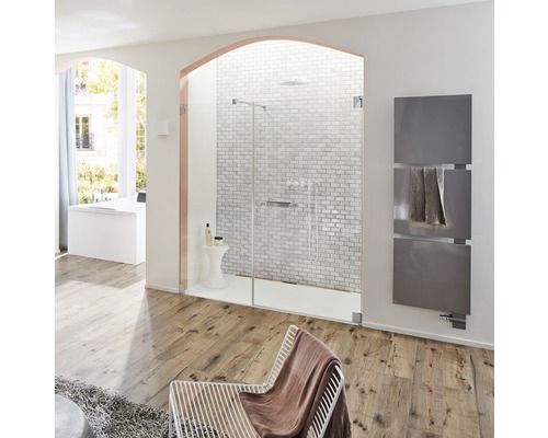 Salle de bains lumineuse avec douche, sèche-serviettes, fauteuil et plancher en bois