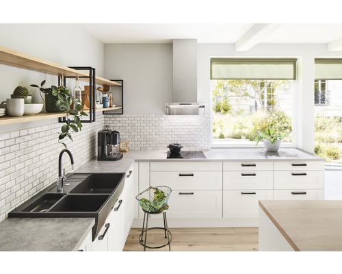 Cuisine lumineuse avec évier, robinet, étagères et appareils de cuisine.