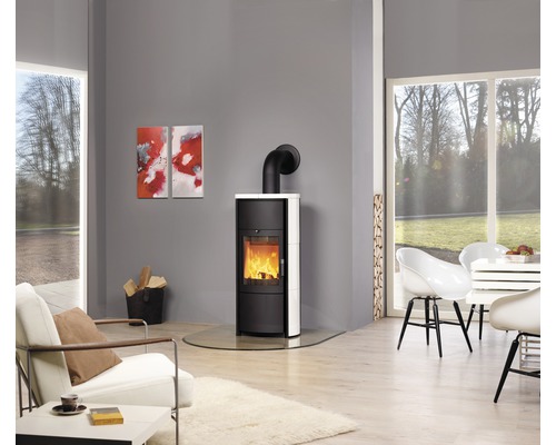 Salon avec poêle à bois sur plaque de sol en verre, fauteuils et table à manger