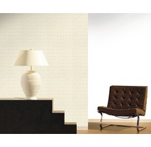 Raumansicht mit gemusterter Tapete, Lampe und Sessel