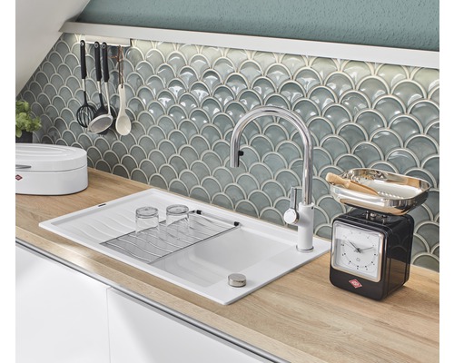 Küchenszene mit Spüle, Armatur, Geschirr und Küchenwaage