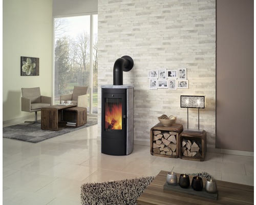 Salon avec poêle à bois, fauteuils, table basse et décoration