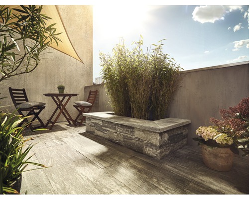 Terrasse aménagée avec plancher en bois, auge en pierre et coin salon