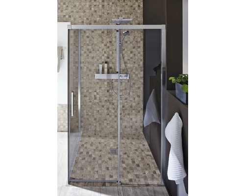 Begehbare Dusche mit Mosaikfliesen an Wand und Boden sowie Duschsystem