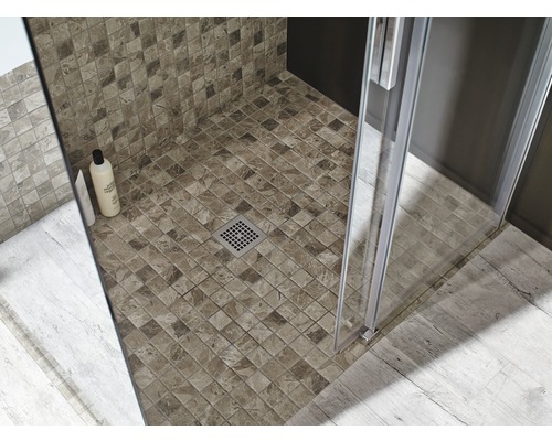 Detailansicht einer Dusche mit Mosaikfliesen, Duschkabine und Ablauf