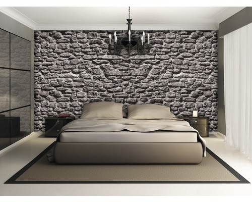 Schlafzimmer mit Steinwandtapete, Doppelbett, Nachttischen und Kronleuchter