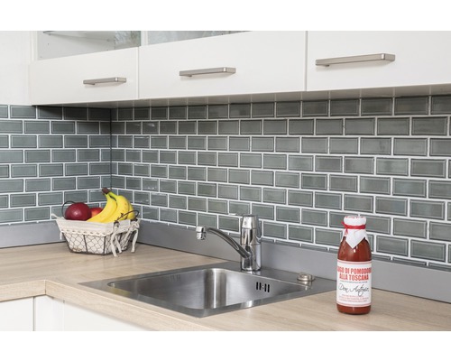 Scène de cuisine avec évier, robinet, carrelage et produits alimentaires