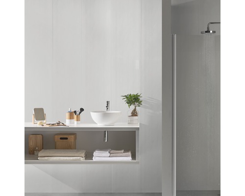 Salle de bains avec lavabo, serviettes et douche pour une ambiance lumineuse et organisée.