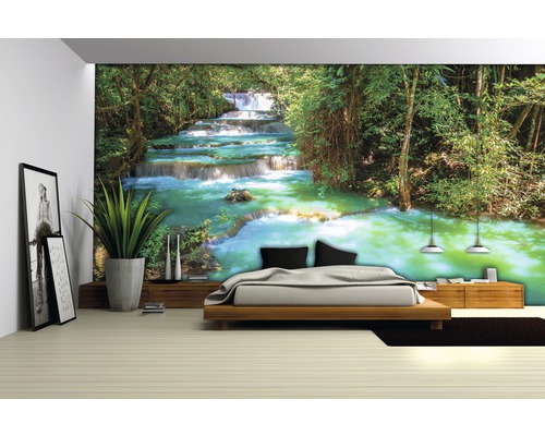 Raum mit Fototapete mit Wasserfallmotiv hinter einem Bett