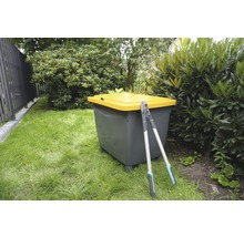 Scène de jardin avec composteur et sécateur sur une pelouse