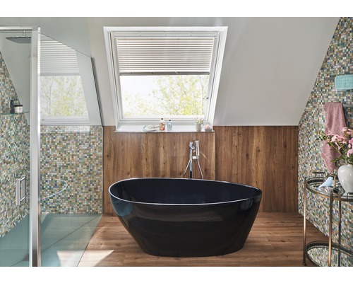 Salle de bain lumineuse avec fenêtre de toit, baignoire îlot et carreaux de mosaïque