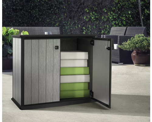 Gartenschrank mit geöffneten Türen und darin gestapelten Kissen im Aussenbereich